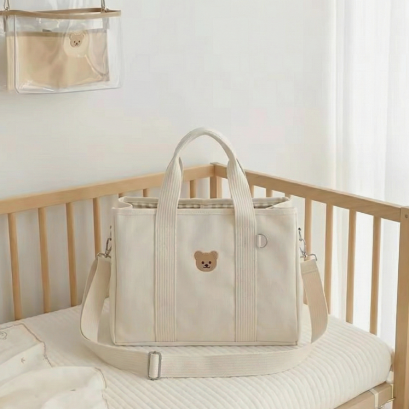 Baby Diaper Bag Handbag Style With Drawstring on a wooden crib
