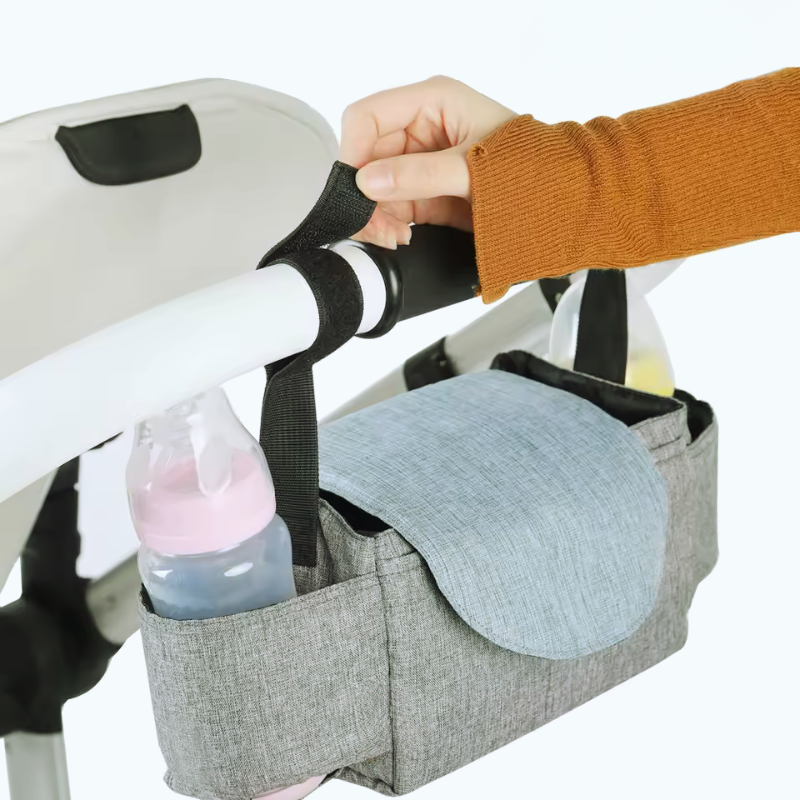 Stroller Baby Diaper Bag with Hasp Closure with a bottle and wipes attached to a stroller.